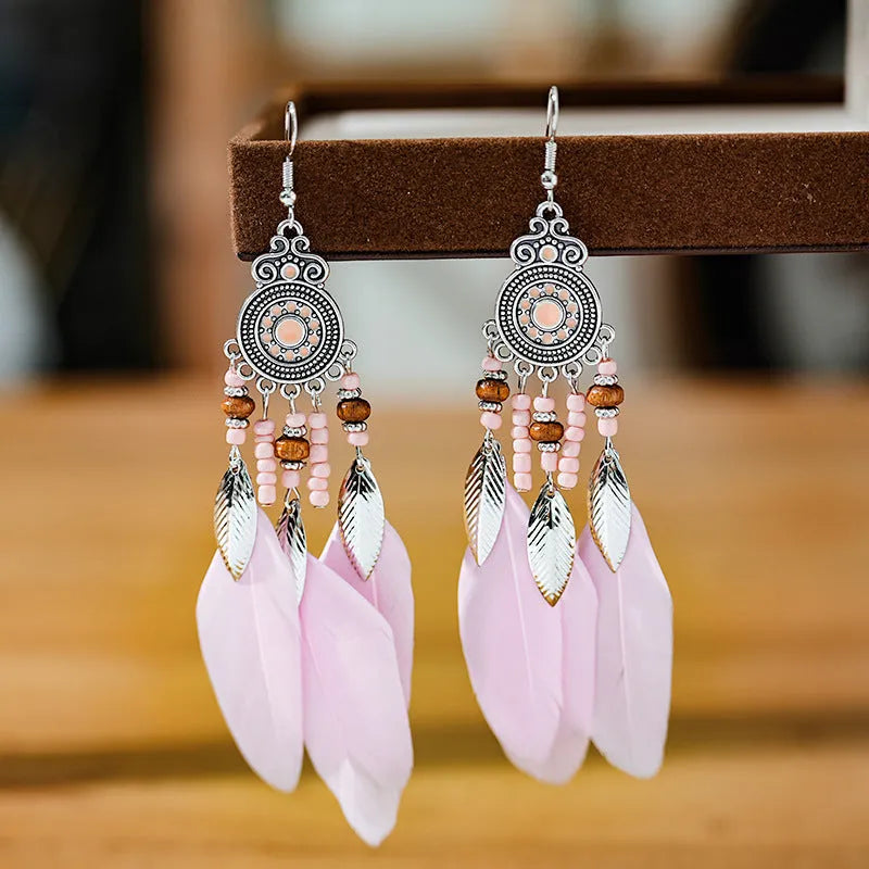 A pair of bohemian-style round drop earrings with a feather leaf pattern, shown in one of thirteen available colours.