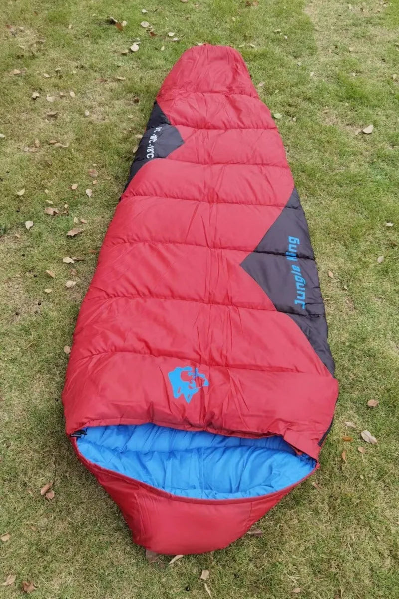 Outdoor cotton sleeping bag in army green with its compression storage bag laid alongside.