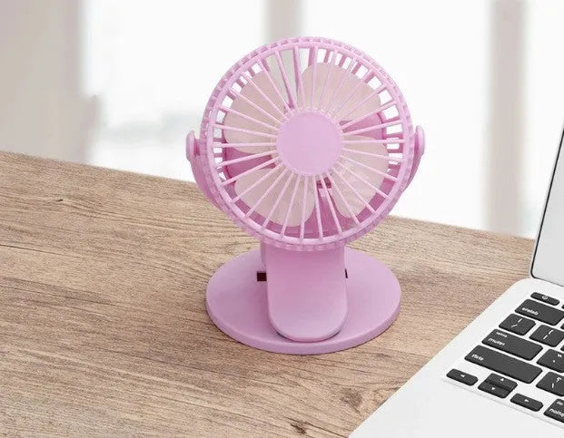 White USB rechargeable mini clip fan with plastic blades attached to a stroller handle.