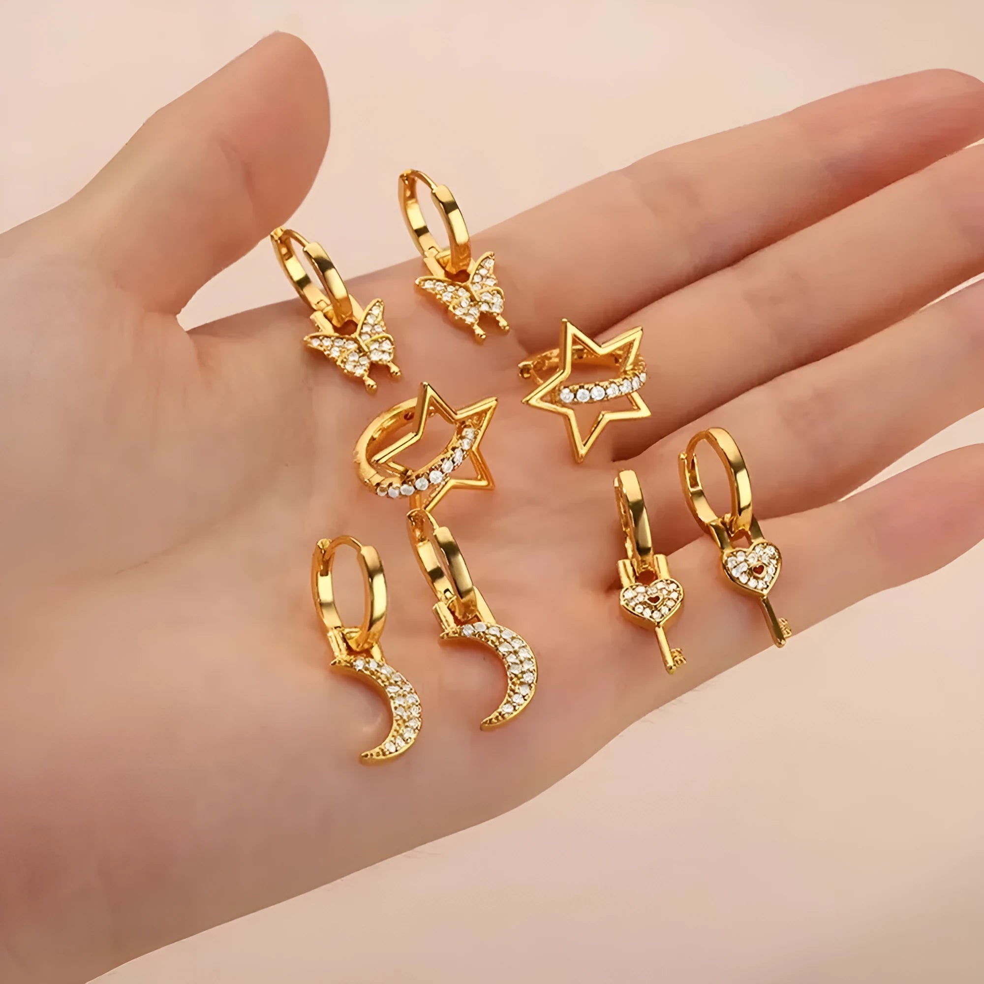 Geometric butterfly-shaped earrings with heart, bow, and star details in copper with a diamond-cut finish.