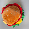 Cartoon burger fabric headdress collar for a small dog or cat on a table.