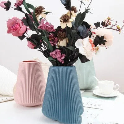 Melamine plastic flower vase in blue colour on desktop with white flowers