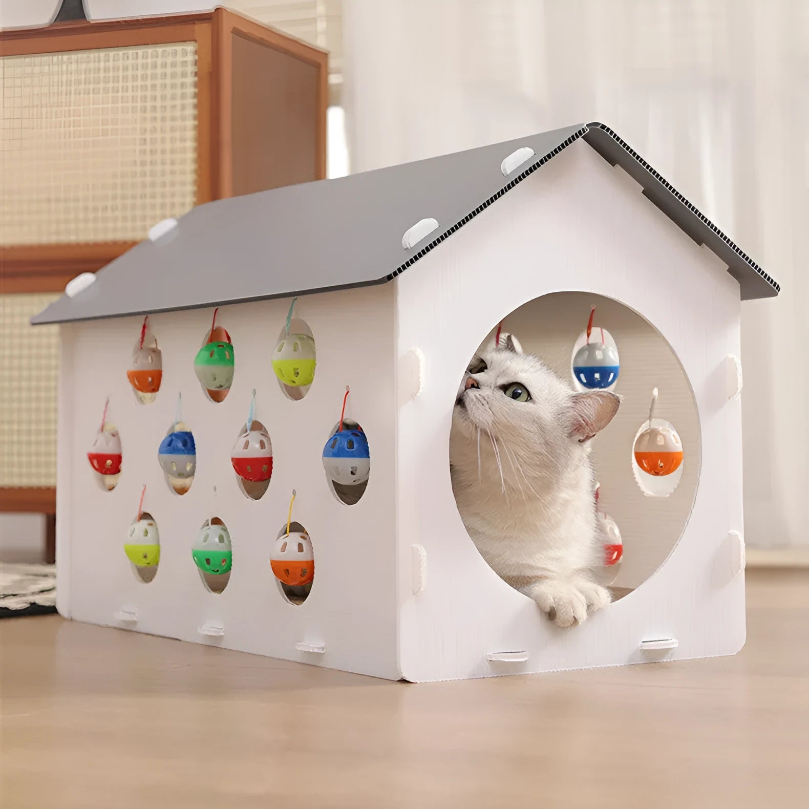 Plastic cat scratch board house with integrated nest bed, bell ball toy, and tunnel opening for indoor feline use