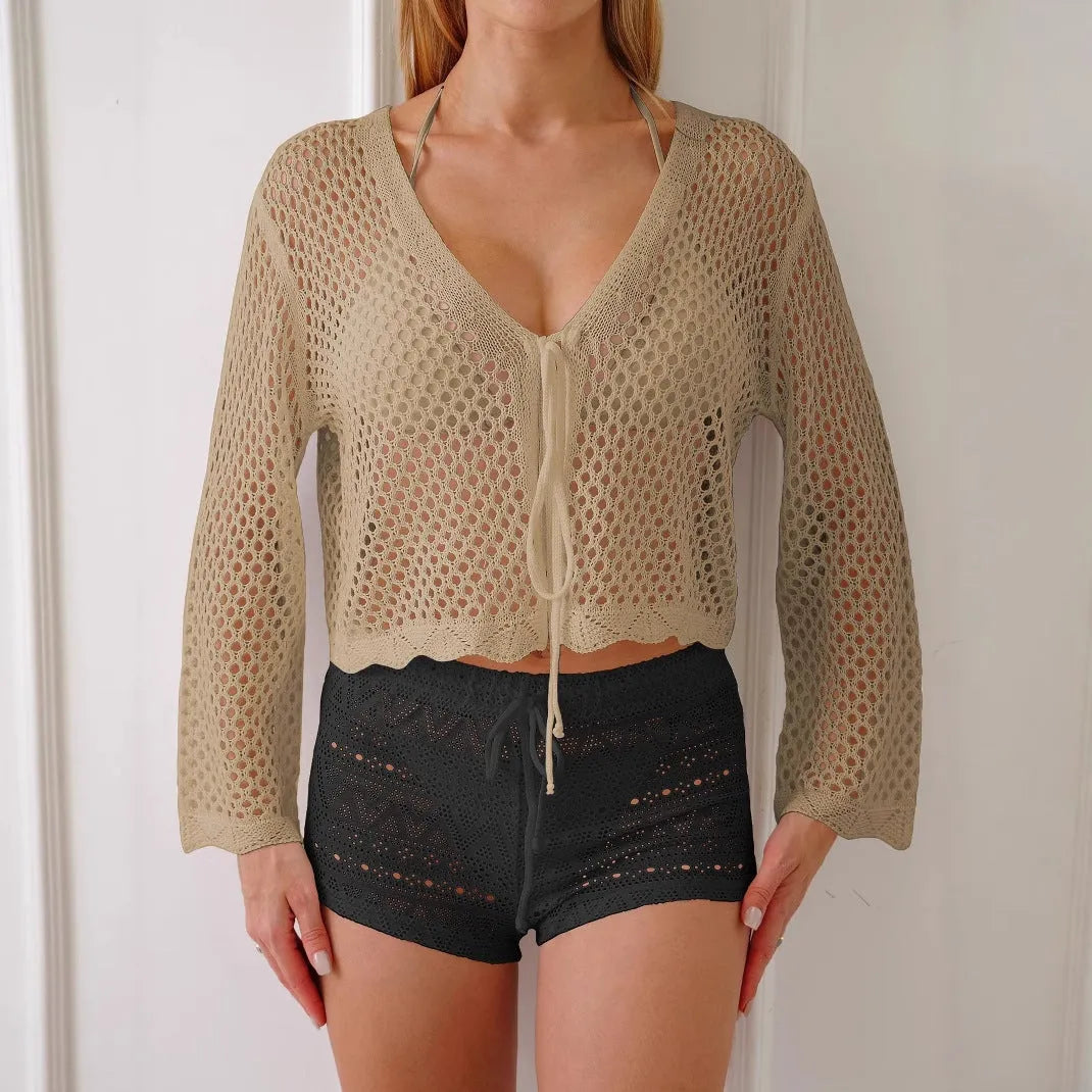 Women's apricot bell sleeve hollow knit cardigan blouse on a hanger.