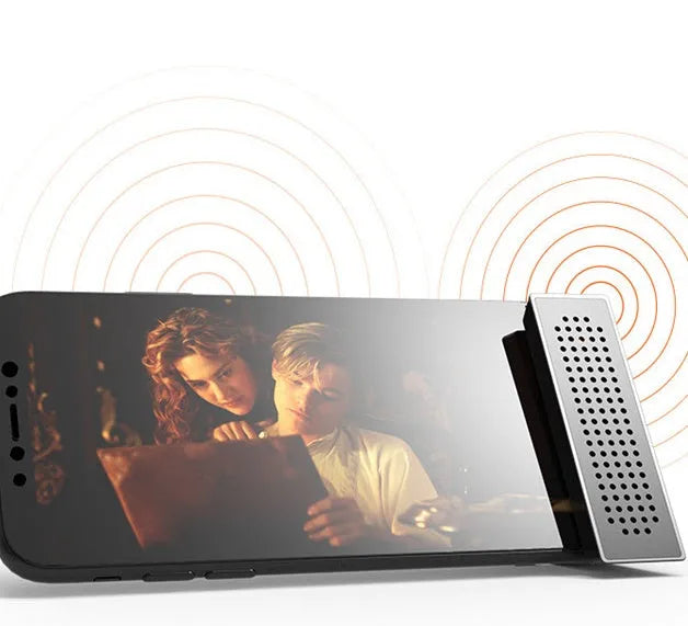 Portable Apple-compatible phone amplifier bracket in multiple colours on desktop