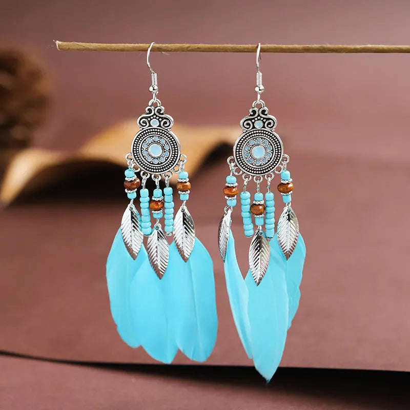 A pair of bohemian-style round drop earrings with a feather leaf pattern, shown in one of thirteen available colours.