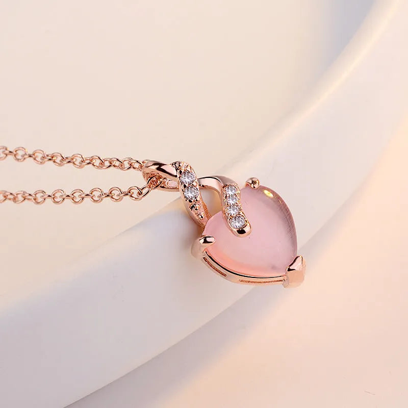 Women's rose gold heart pendant necklace with pink crystal on cross chain