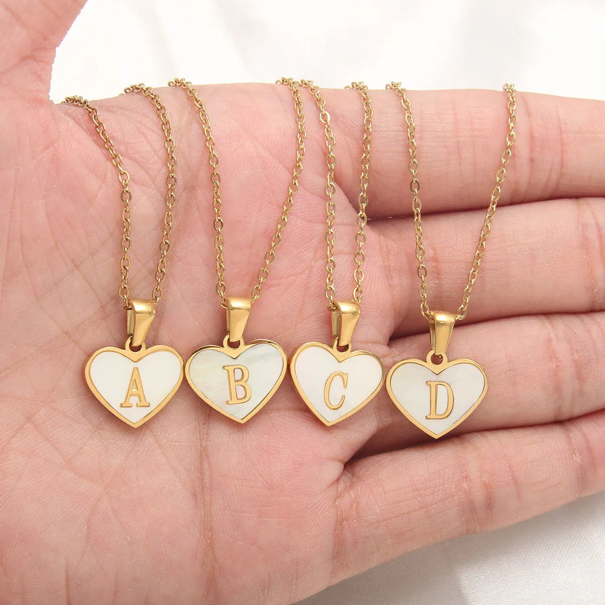 Gold plated heart-shaped white shell pendant personalised initial necklace on a stainless steel chain.