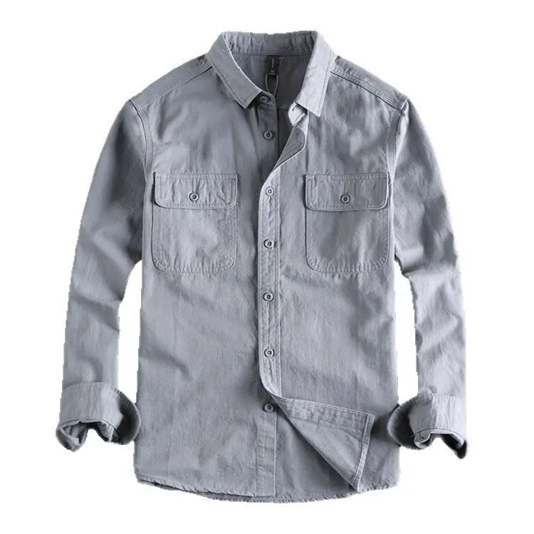 Man wearing a loose grey cardigan-style button-up shirt with long sleeves.