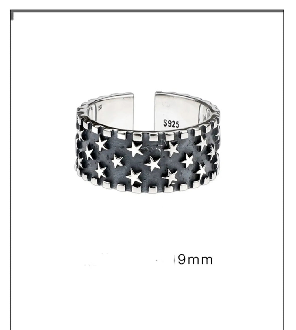 Close-up of a sterling silver ring with a geometric five-pointed star design on an adjustable band.