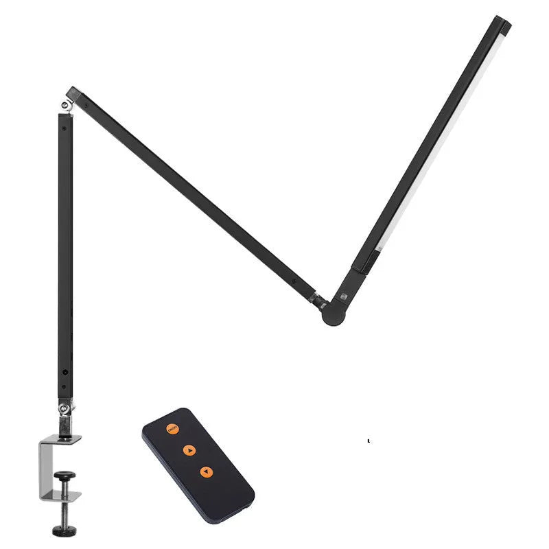 Black adjustable clip-on desk lamp with flexible arm and remote control on a wooden desk