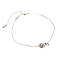 Close-up of a gold-coloured alloy bracelet with a pineapple charm on a simple chain.