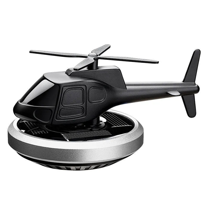 Silver metal helicopter car air freshener with rotating blades on dashboard