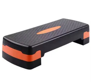 Grey, green, and orange fit step aerobics equipment on a plain background.