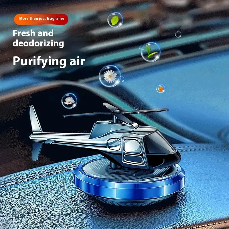 Silver metal helicopter car air freshener with rotating blades on dashboard