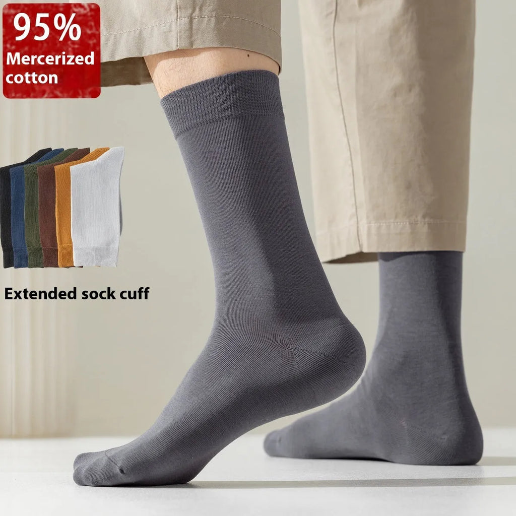 Mid-calf men's socks in solid colours made from combed cotton, shown in a stack.