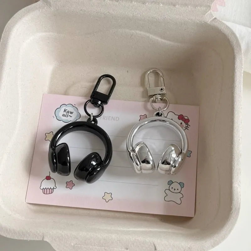 Small earphone pendant keychain with baking varnish finish in black on grey background