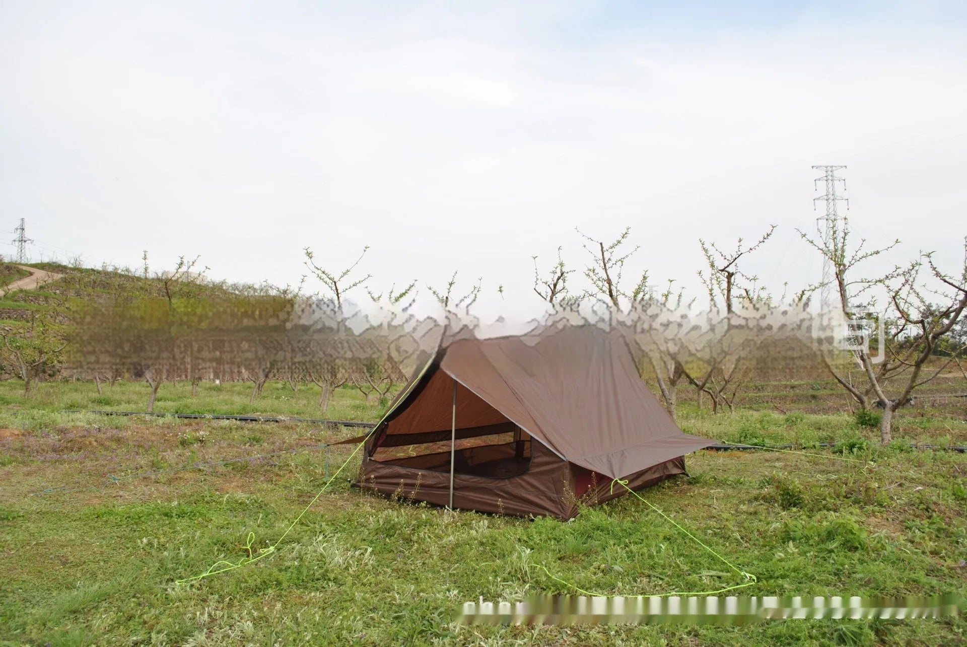 Brown A-line cabin tent pitched with hiking poles as structural support showing spacious interior for 2-3 people