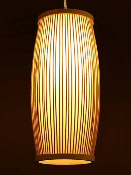 Small woven bamboo table lamp with a natural finish, shown on a wooden surface.