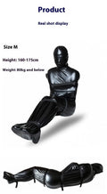 Black patent leather bondage restraint kit with body wrap and six ratchet tie-down straps laid out.