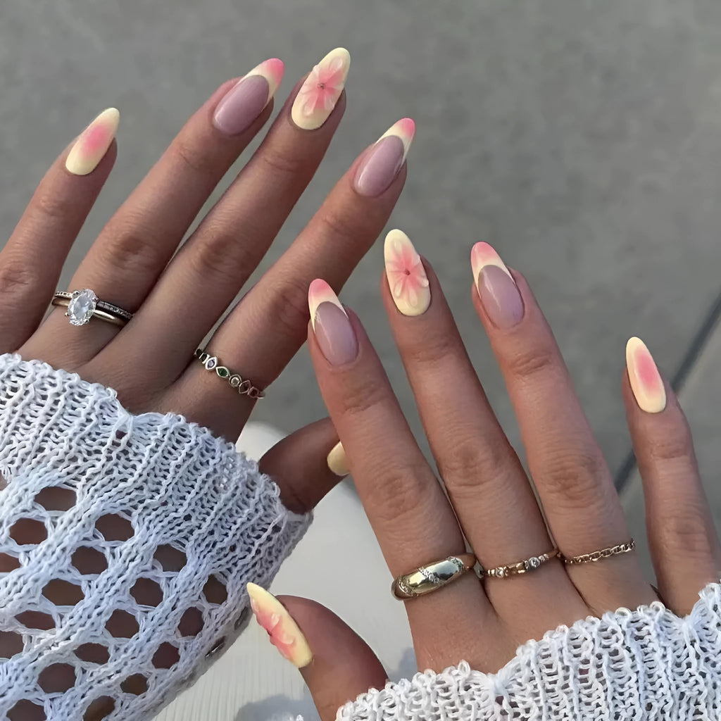 Set of simple fake nails with pink and white cartoon 3D flower charms on a wearable armour base.