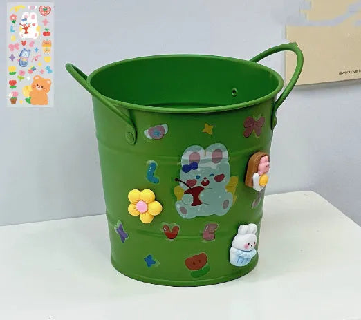 Round metal Creative Iron Art pen holder shown in pink, green, red, white, and yellow colour options on a desk.