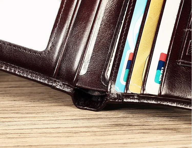 Men's black leather bifold wallet open to show internal card slots, photo window, coin pocket, and banknote compartment.