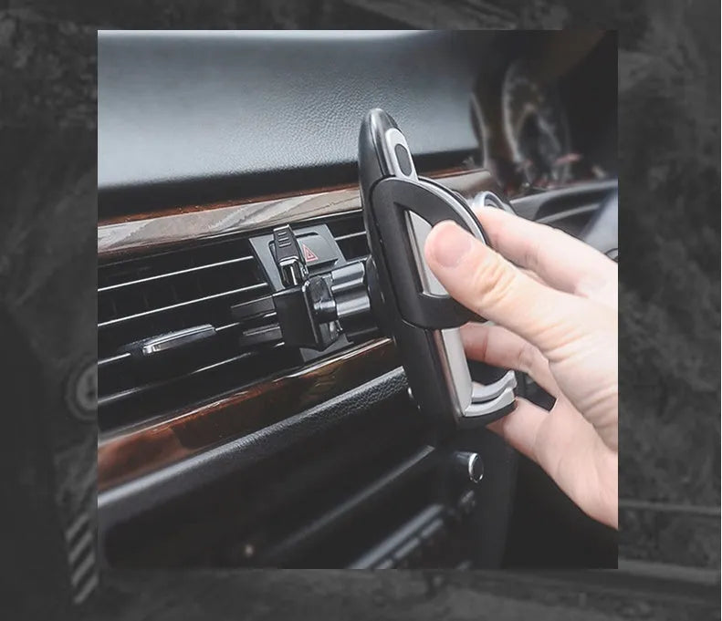 Black plastic mobile phone holder mounted on car air conditioning outlet with phone inserted
