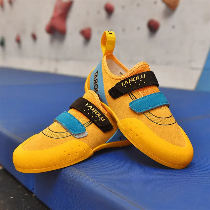 Pair of beginner rock climbing shoes with Velcro strap and black and red rubber outsole.