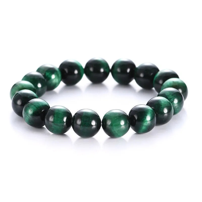 Polished green tiger eye stone bead bracelet on a wrist, showing geometric bead shapes.