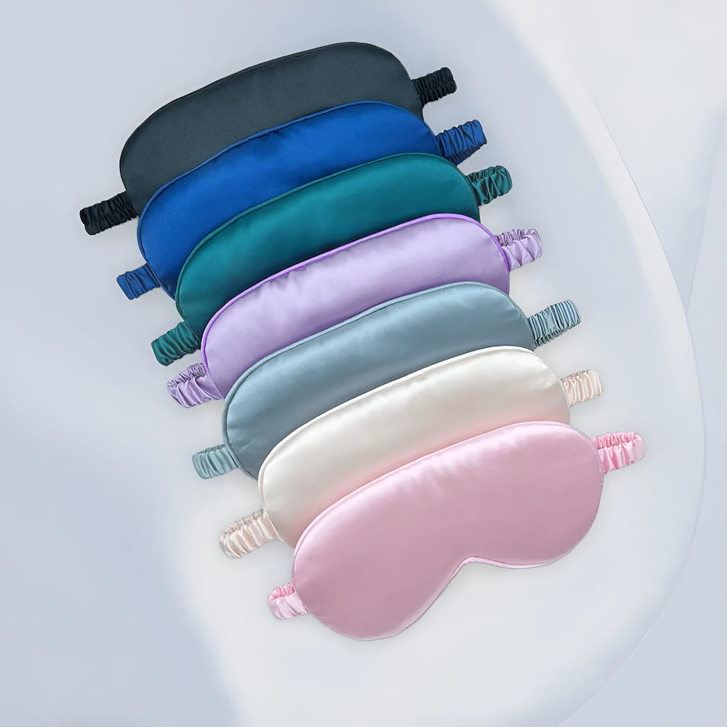 Reversible silk-like sleep eyeshade shown in multiple colour options including sky blue, wine red, and black.