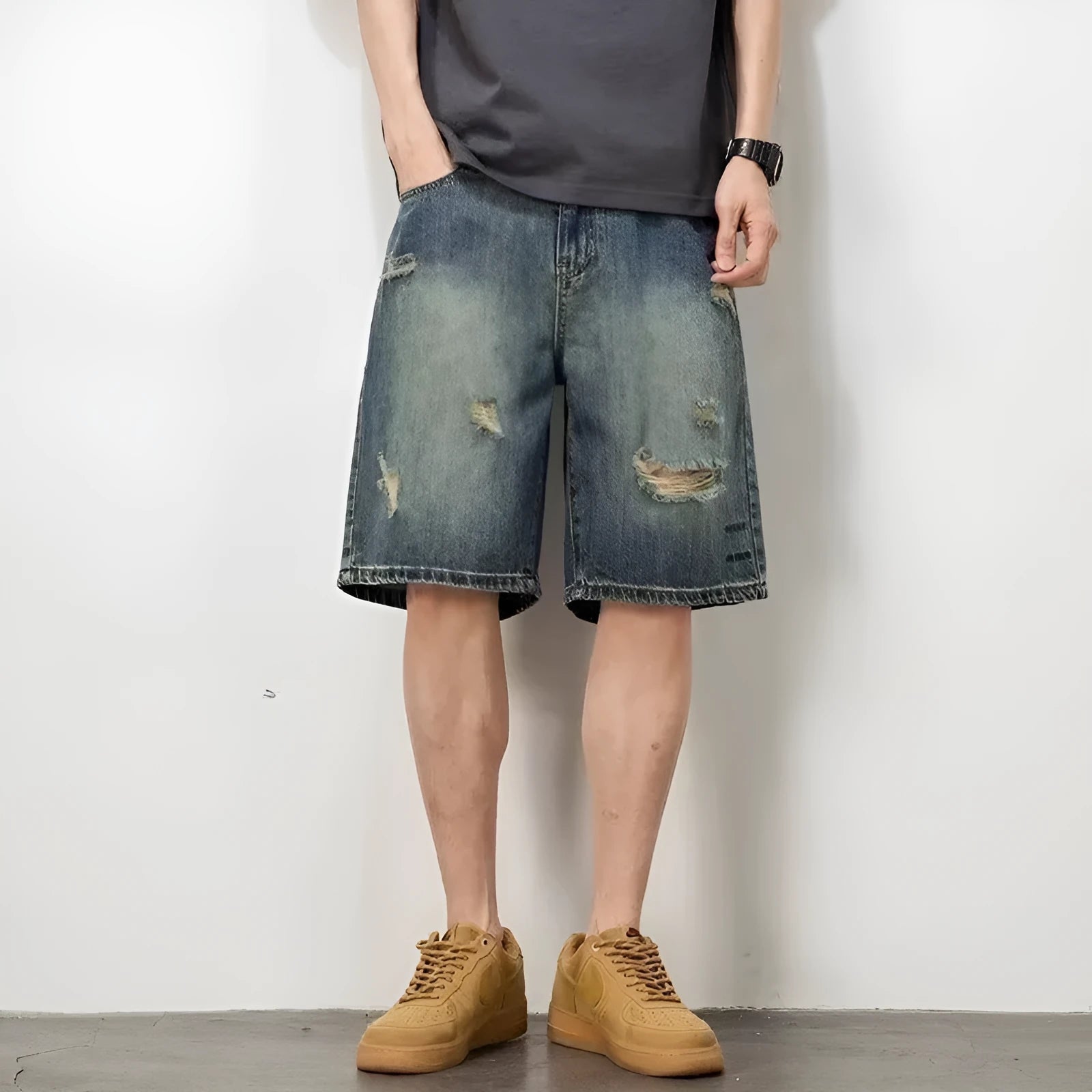 Blue denim men's shorts with distressed holes and straight cut design on mannequin
