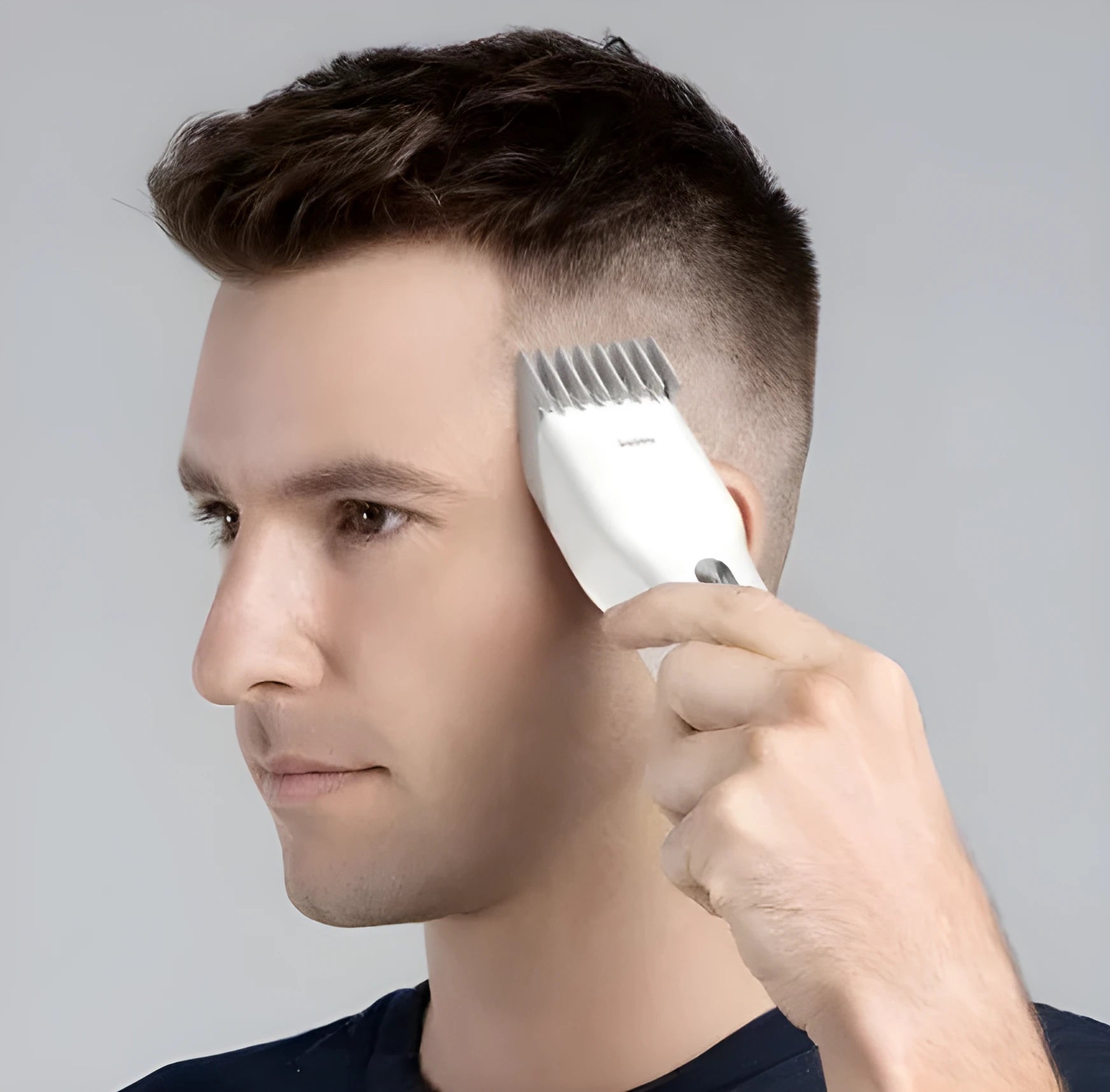 Black and white cordless electric hair clippers with adjustable comb on a stand