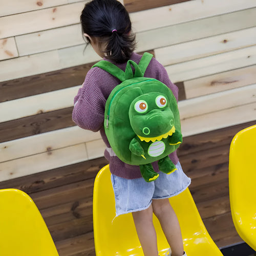 Blue baby dinosaur plush backpack with embroidered detail and a soft handle.