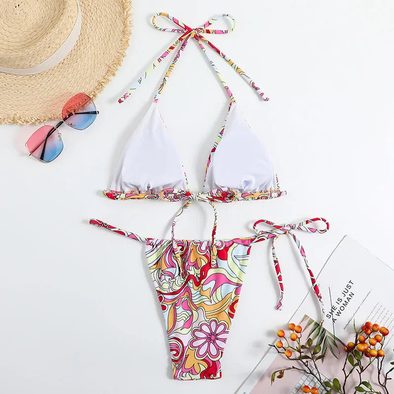 Multicolour printed women's triangle bikini set with hanging neck top and separate bottoms.