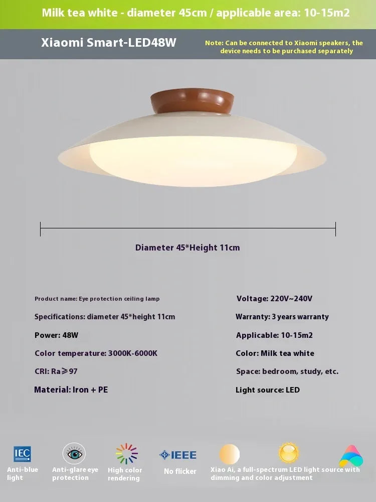 Modern minimalist flying saucer design ceiling lamp in cream yellow on a white ceiling.