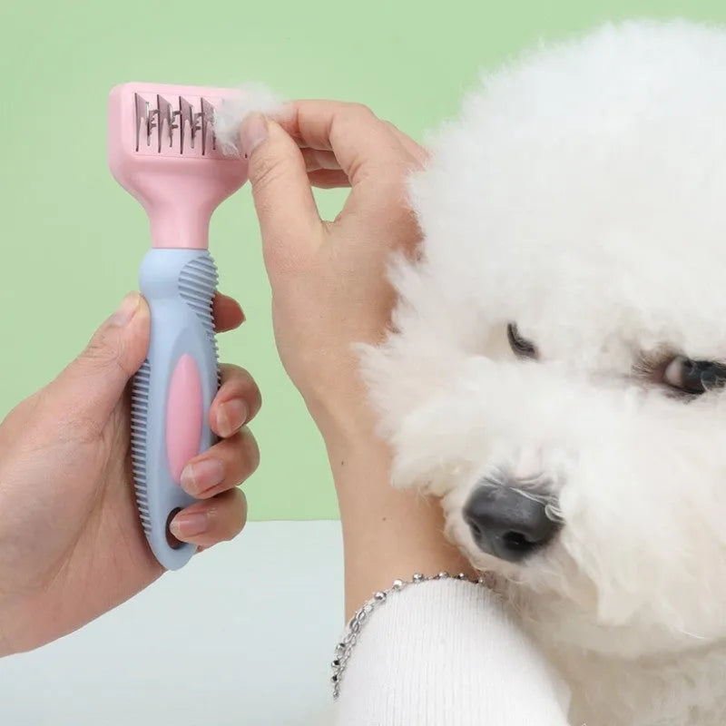 Pink stainless steel pet comb with comb teeth and an integrated knot-cutting knife blade.