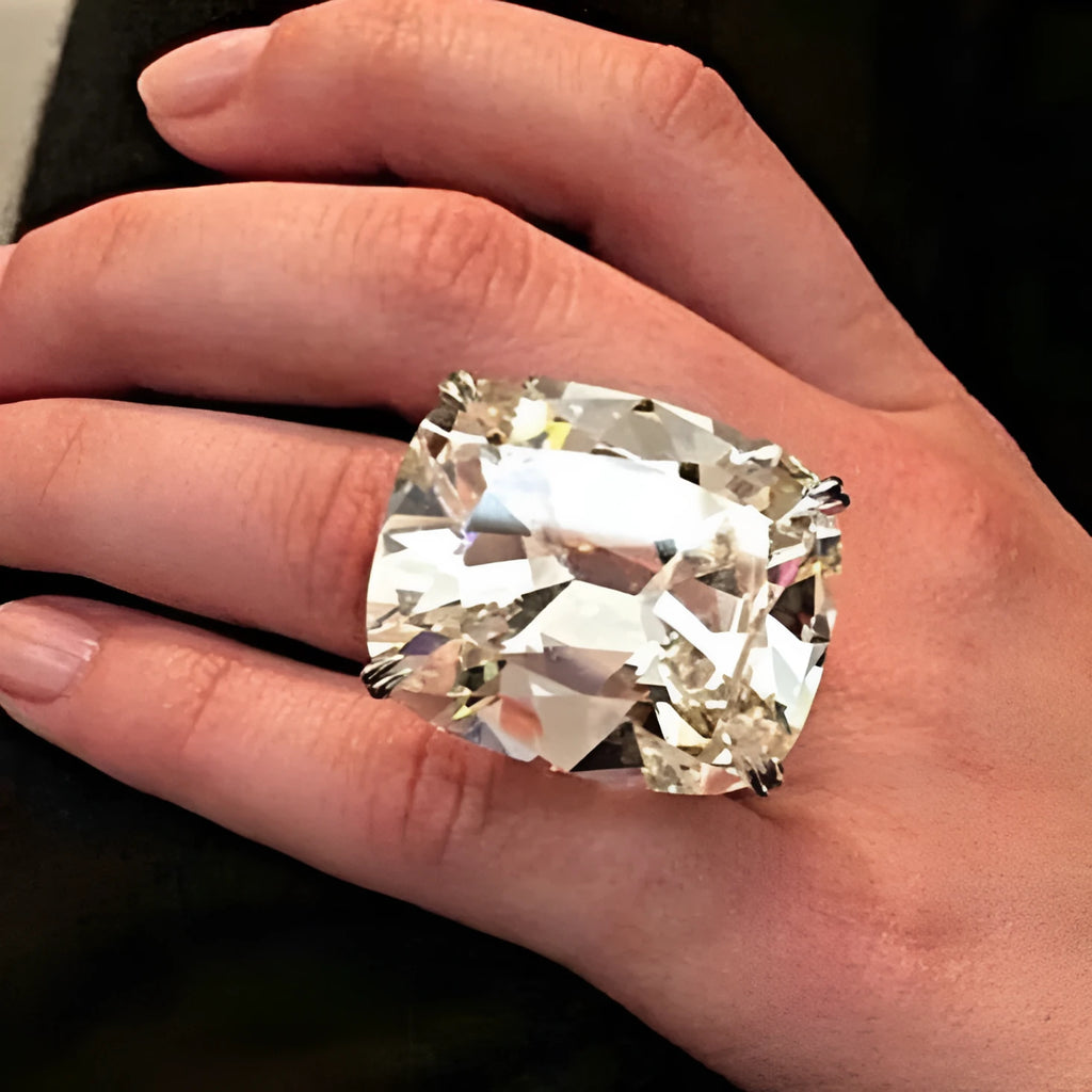 Simple white gold colour women's ring with an inlaid square diamond, showing geometric design.