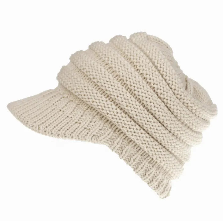 Women's knitted ponytail beanie with hair hole opening in acrylic yarn, shown in beige colour