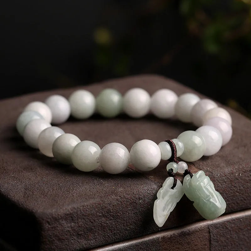 Natural green jade bracelet with hanging geometric charms including an Apple and a Maitreya Buddha pendant.