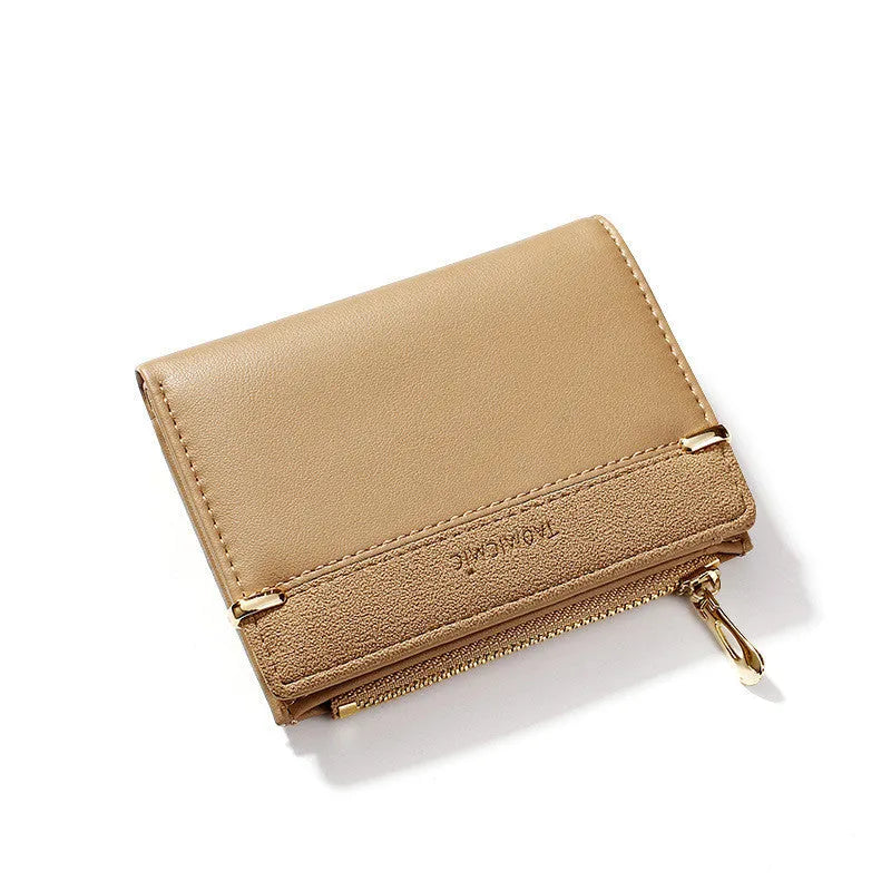 Black ladies folding wallet with a short zip, open to show multiple card slots, bill holder, and change compartment.