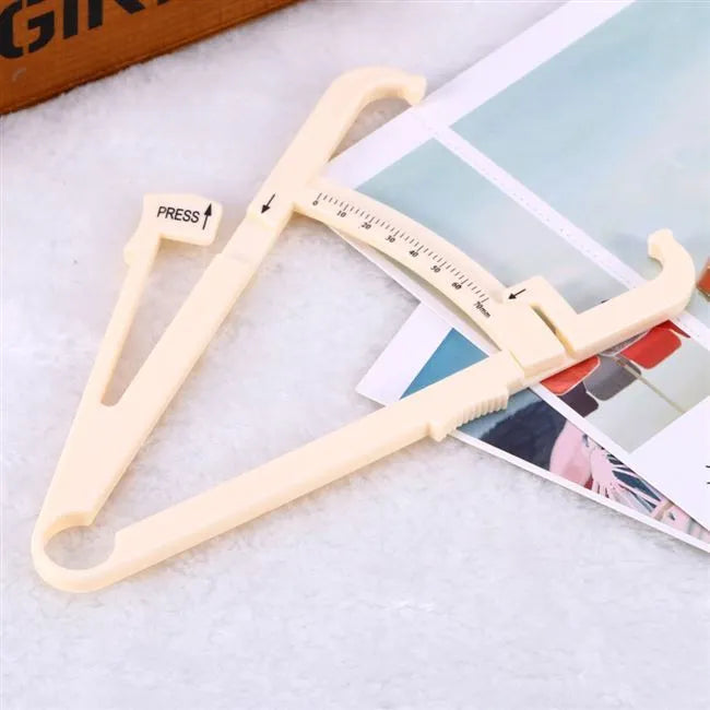 White acrylic body fat caliper with measurement scale for skinfold thickness testing.
