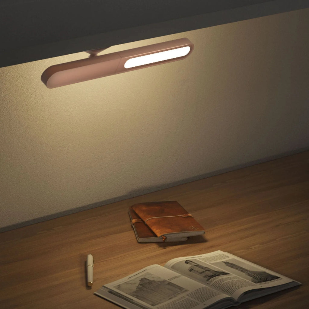 Geometric desk lamp with magnetic base shown attached to metal surface as wall light