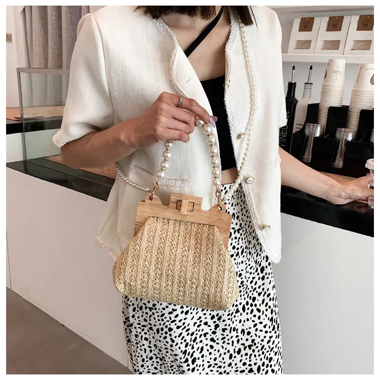 Women's woven straw shoulder bag with pearl chain detail in beige colour, showing interior organiser pockets.