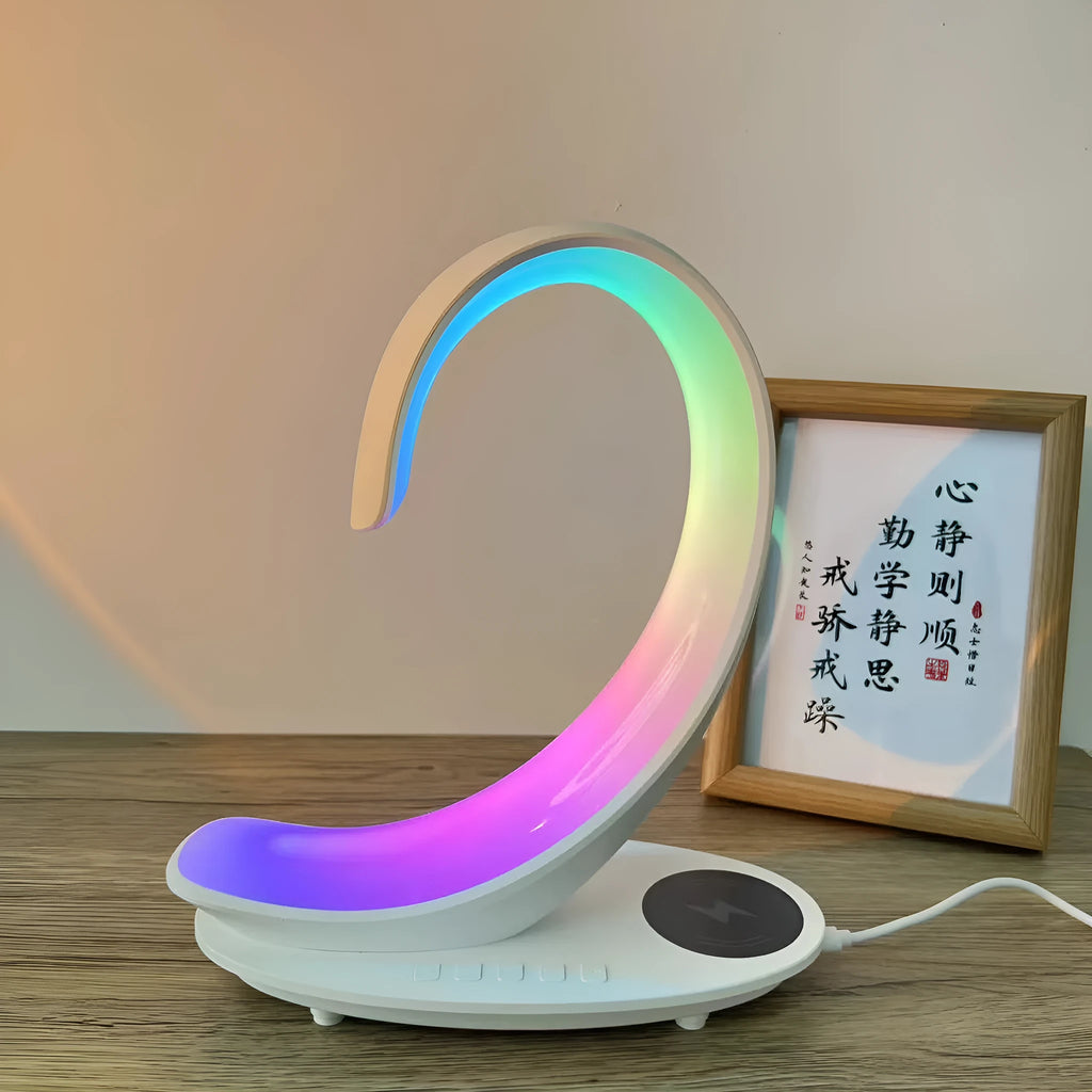 White swan wireless charging Bluetooth speaker with colourful ambient lighting on desktop