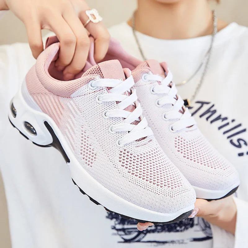 Women's pink Flyknit casual running shoes with mesh lining and flat PVC sole.