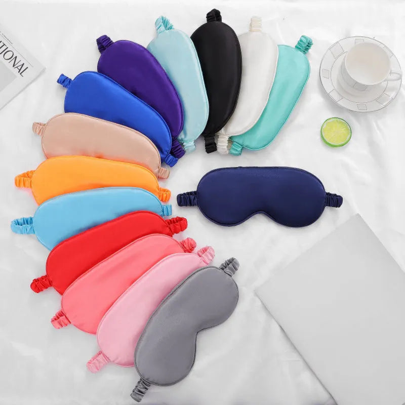 Reversible silk-like sleep eyeshade shown in multiple colour options including sky blue, wine red, and black.
