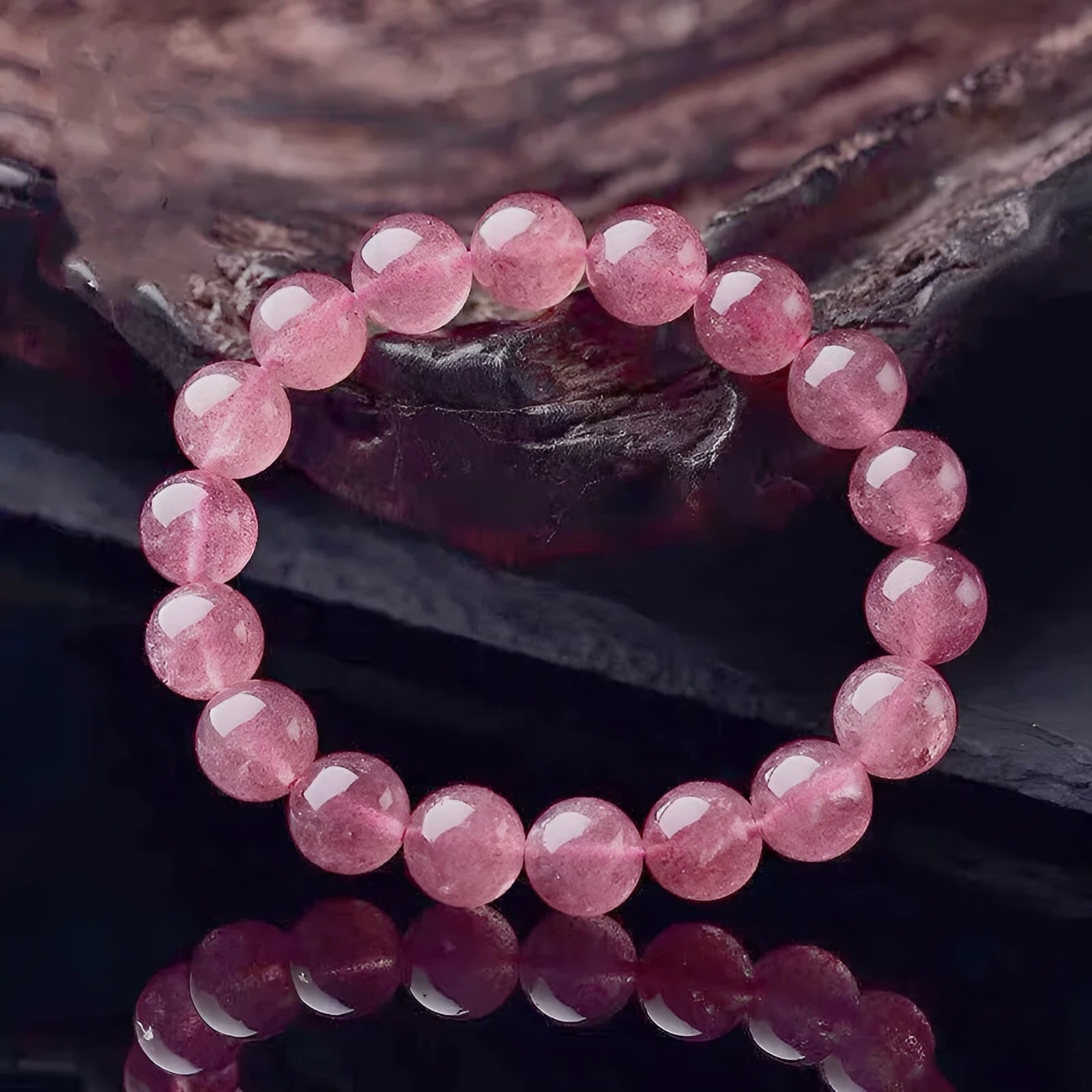 Women's strawberry quartz crystal bracelet with polished beads, showing size options of 6mm, 8mm, and 10mm.