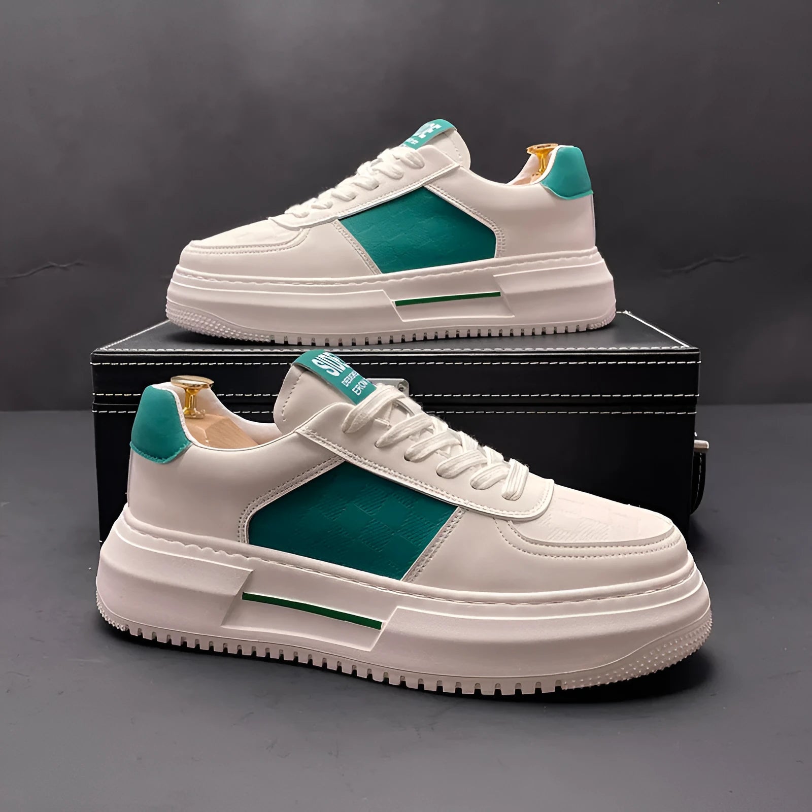 White and green sports casual shoes with cloth upper and rubber foam sole on a plain background.