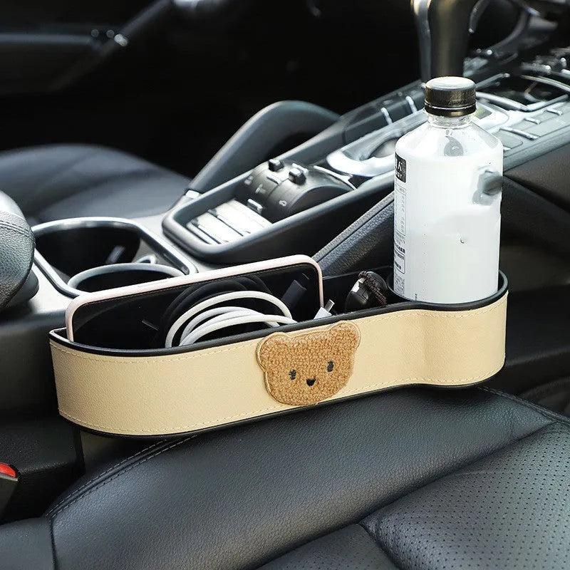 PU leather car seat gap storage box hanging between vehicle seats for small item organisation.